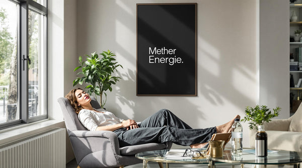 Professional woman powernapping in bright office lounge with 'Mehr Energie' poster